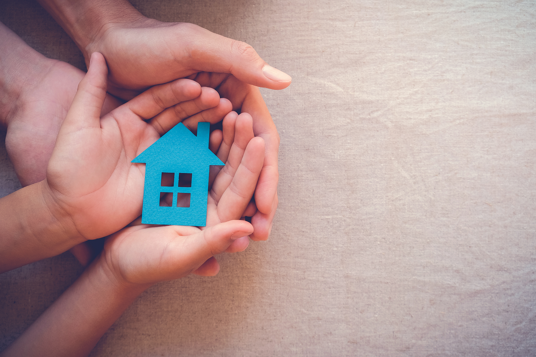 hands holding a blue house