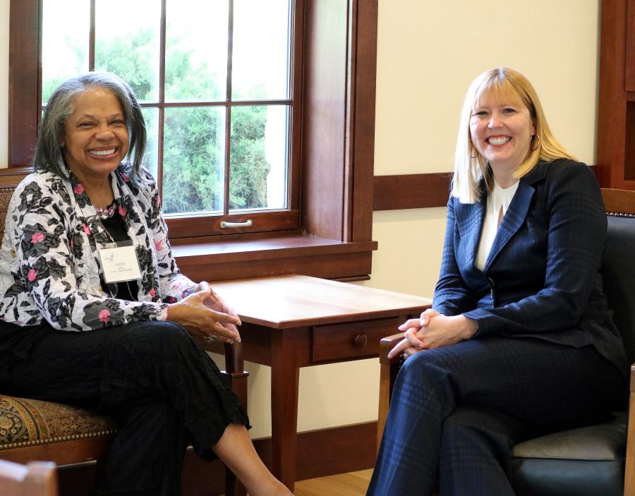 Valerie and Meghan sitting in chairs near a window smiling