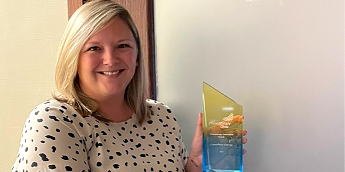 woman standing in front of door holding glass award in hands