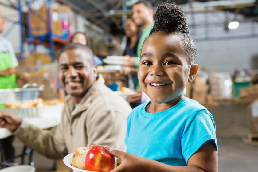 child at food bank with apple